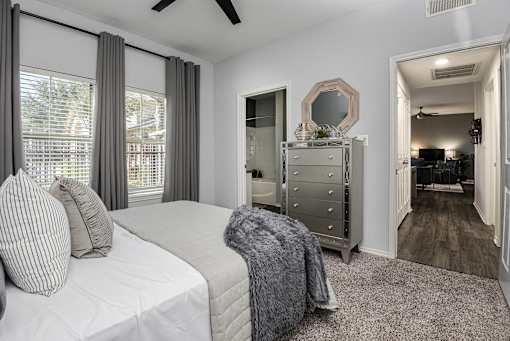 a bedroom with a bed and a dresser and a mirror