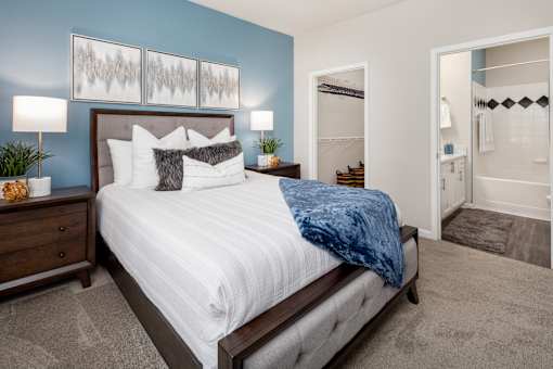 A bedroom with a bed, nightstand, and two lamps.