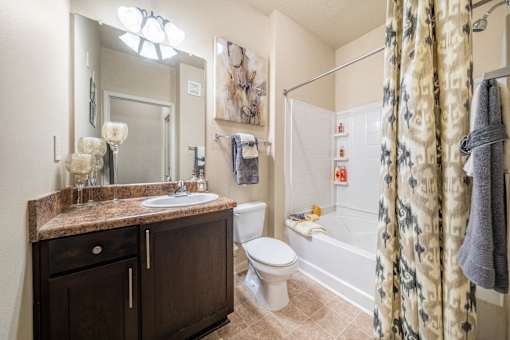 A bathroom with a brown counter top and a white toilet.