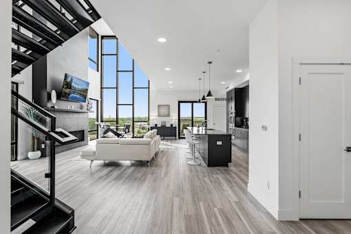 A modern living room with a staircase on the left side.