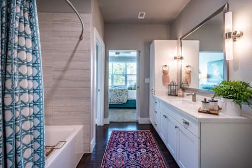A bathroom with a white tub and a white sink.