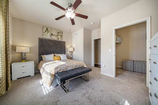A bedroom with a bed, nightstand, and a ceiling fan.
