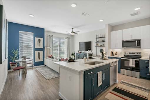A modern kitchen with dark blue walls and white countertops.