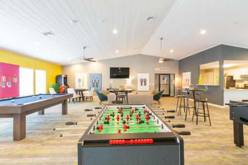 a recreation room with a foosball table and ping pong table