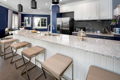 A kitchen with a white countertop and a black refrigerator.