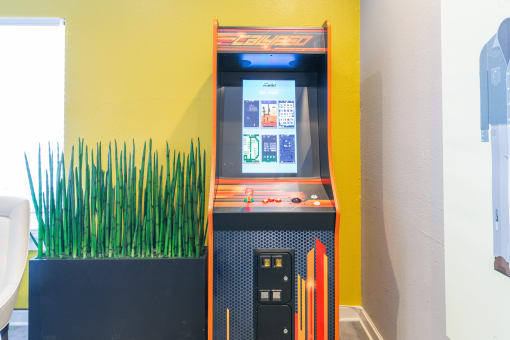 a slot machine in a yellow room with a green plant in the background