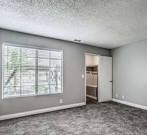 A room with a window and a door leading to another room.