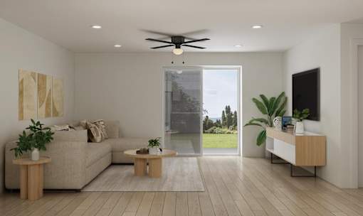 A modern living room with a beige sofa, a coffee table, a ceiling fan, and a large window.