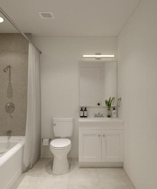 A white toilet sits in a bathroom next to a bathtub.
