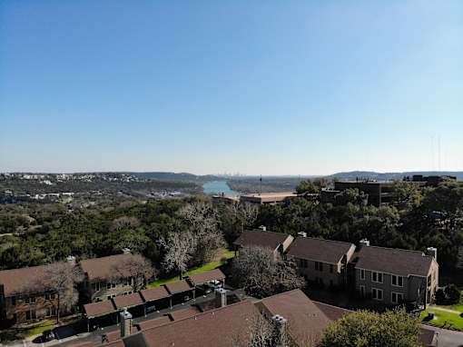 A view of a residential area with houses and a body of water in the distance.