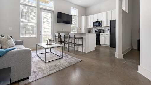 A modern living room with a grey couch and a white coffee table.