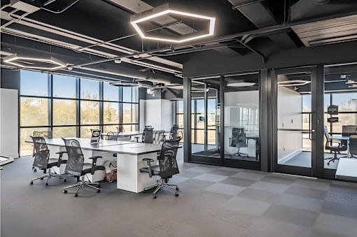 A modern office space with a large desk and chairs.