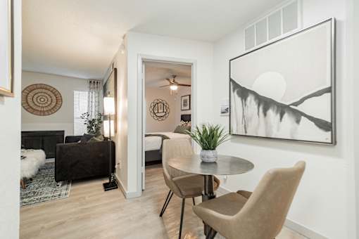 A living room with a grey table and two chairs.