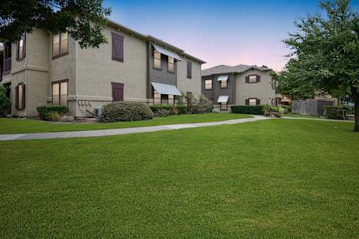 an image of an apartment complex with a green lawn