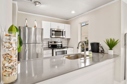 a kitchen with white cabinets and stainless steel appliances