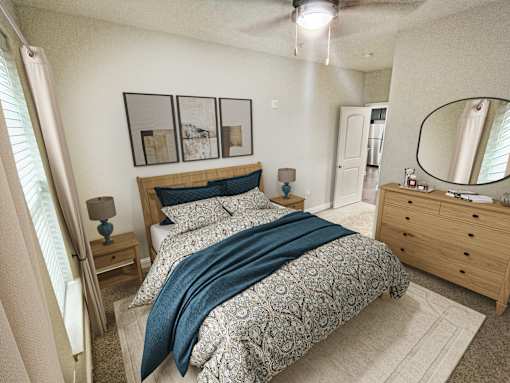 A bedroom with a bed, nightstand, and a dresser with a mirror.
