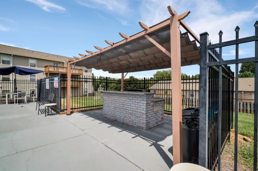 the clubhouse has a patio with a brick fireplace and a gazebo
