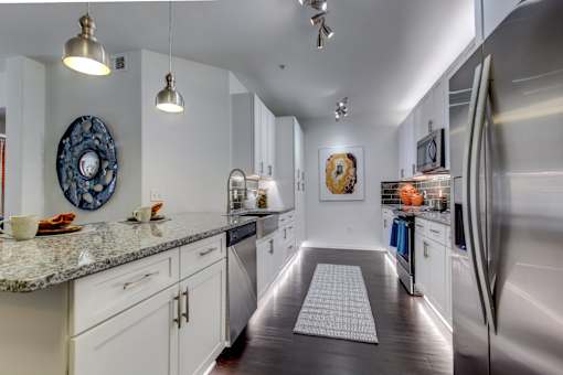 a kitchen with white cabinets and stainless steel appliances