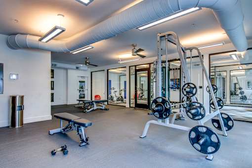 a gym with weights and other equipment in a building with glass doors
