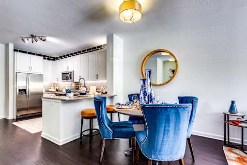 a kitchen and dining area with a table and chairs and a refrigerator