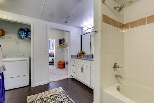 a bathroom with a shower and a sink and a washing machine