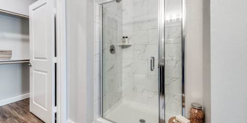A white bathroom with a walk in shower.
