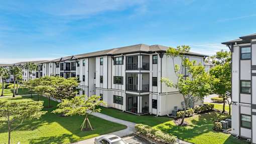 A row of modern townhouses with green lawns in front.