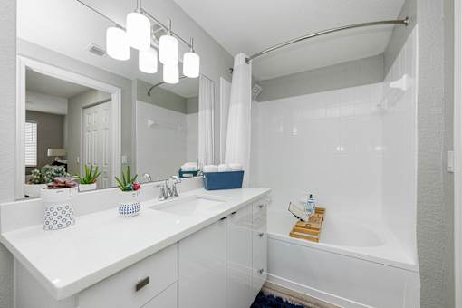 A white bathroom with a white tub and sink.