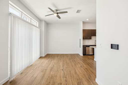 A room with a ceiling fan and wooden flooring.