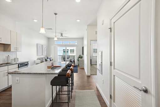 A modern kitchen with a bar area and a view of the outdoors.
