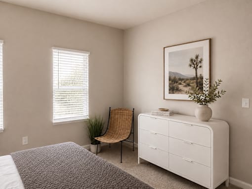 A bedroom with a bed, a chair, a dresser, and a painting on the wall.