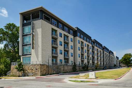 A large building with a stone wall in front of it.