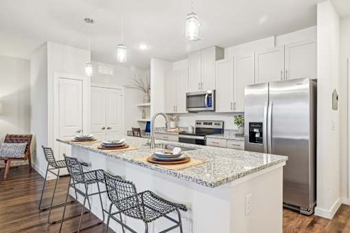 A kitchen with a white countertop and stainless steel appliances.