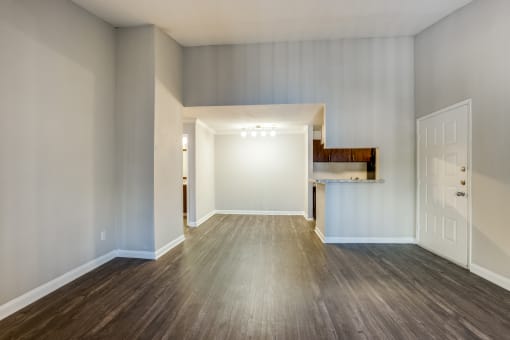 an empty living room with wood flooring and a white door