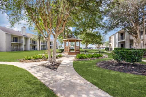 a view of the courtyard of a building with trees and grass