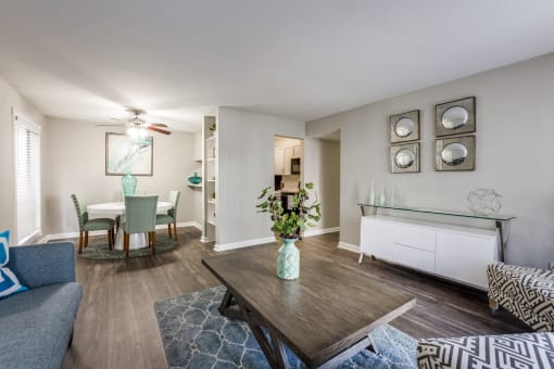 an open living room and dining room with a table and a ceiling fan