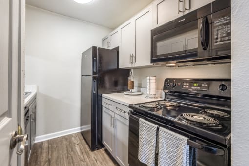 the kitchen of a home with stainless steel appliances and white cabinets