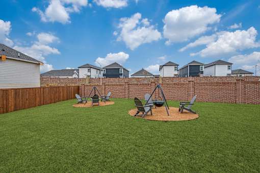 A backyard with a lawn and a swing set.
