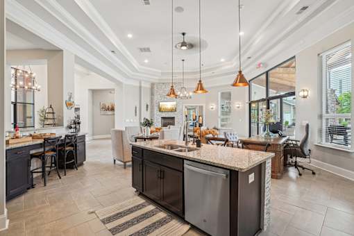 A modern kitchen with a large island and pendant lights.