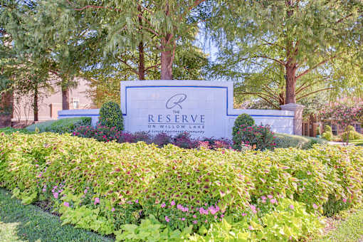 A sign for The Reserve on Willow Lake is surrounded by greenery.