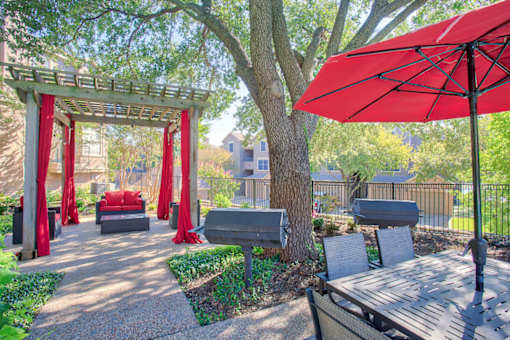 A red umbrella is on the right side of a wooden table.