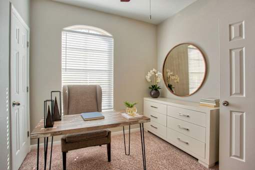 A room with a table, chairs, and a mirror.