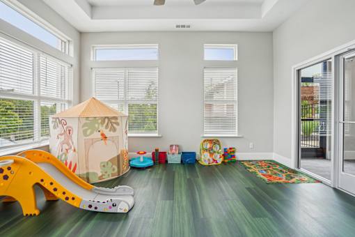 A child's play area with a slide, ball pit, and toys.