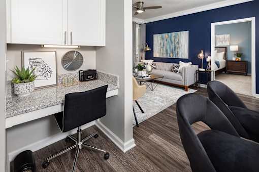 A black chair is in front of a marble counter.