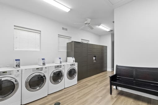a laundry room with washers and dryers and a bench