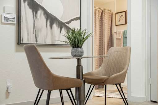 Two chairs and a table with a plant on it.