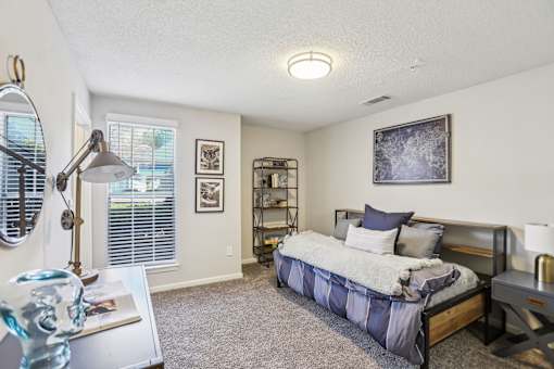 A bedroom with a bed, nightstand, and a lamp.
