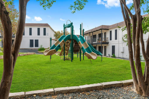 a playground with a slide in front of a building