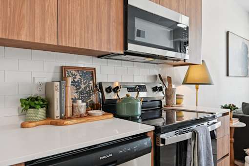 A kitchen with a white countertop and a black stove top oven.