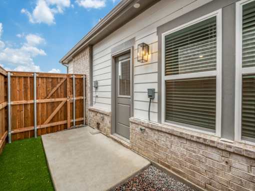 A house with a brown fence and a grey door.